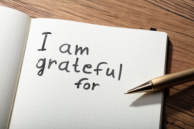 I am grateful written in a journal with the pen sitting on top.