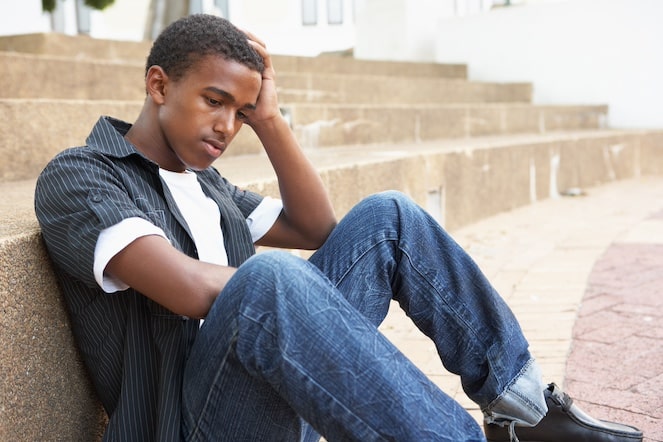 Male athlete sitting unhappy against some steps