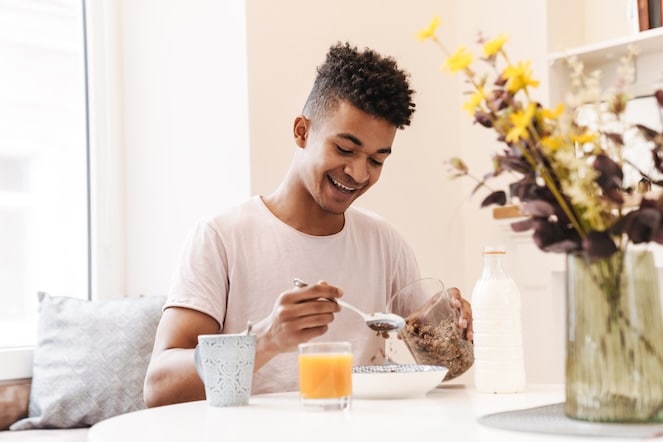 Young African American boy eating a healthy breakfast and smiling