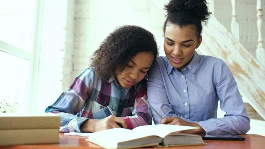 Parent showing support by helping daughter with something.