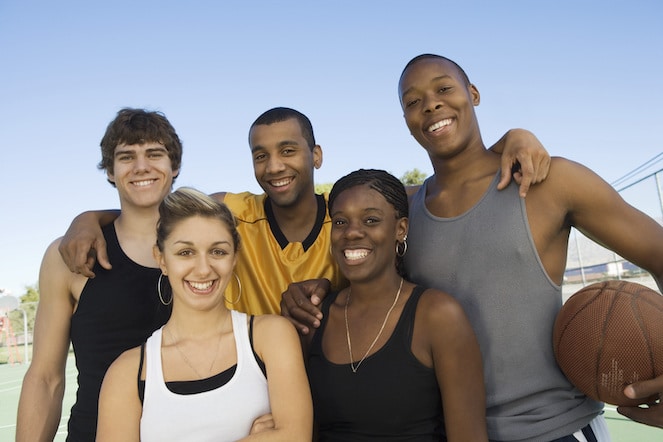 Diverse set of friends and athletes in the park ready to play basketball.